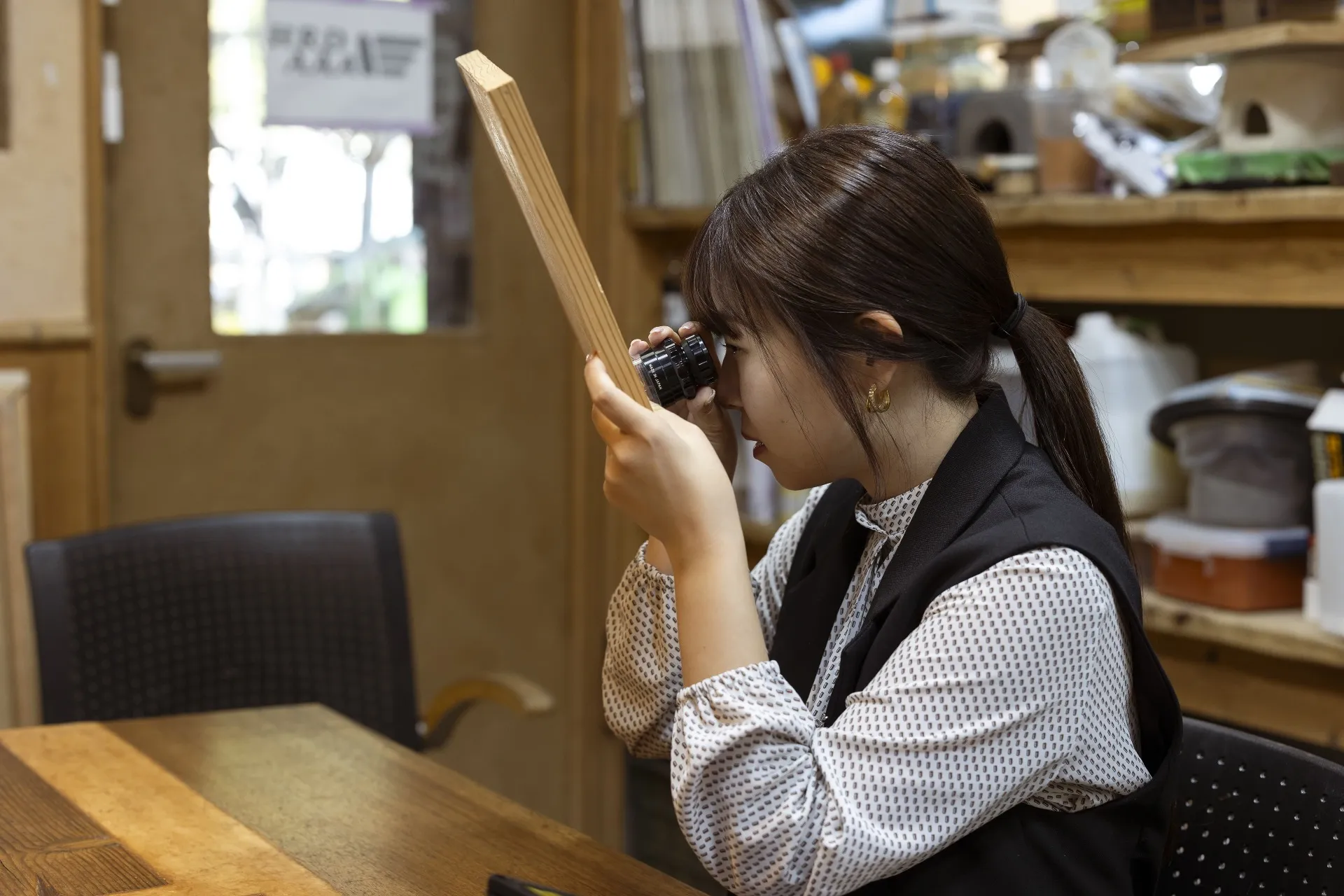 ルーペで覗く石井さんの写真